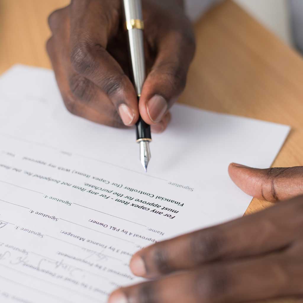 cropped-hand-businessman-writing-document-table-office
